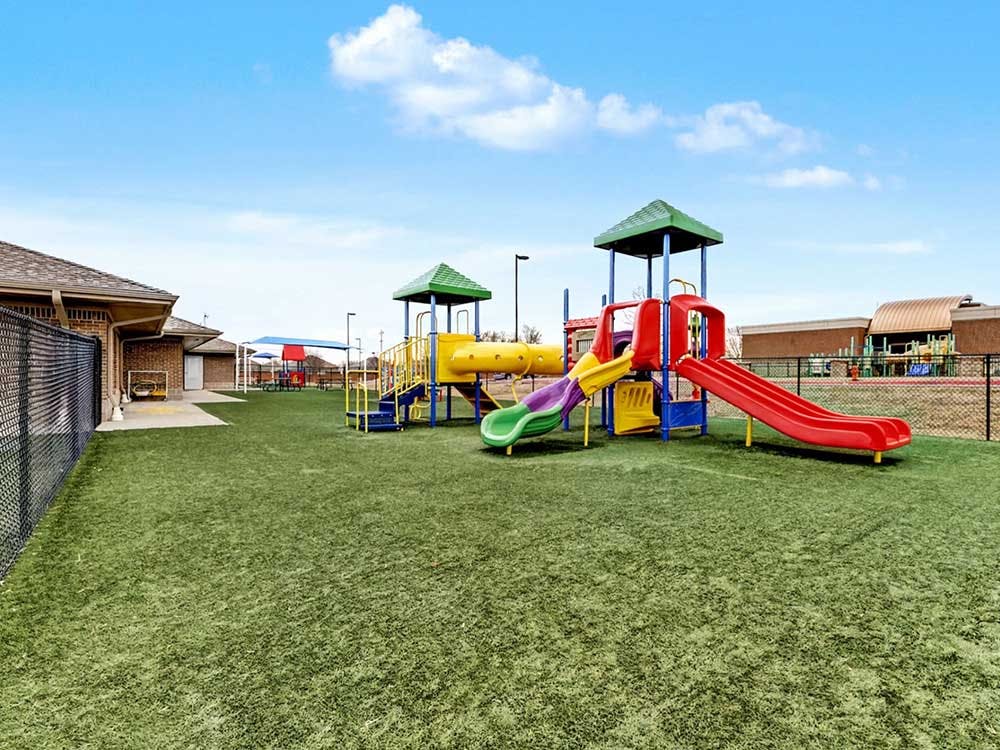 Colorful playground with slides and climbing structures on artificial turf