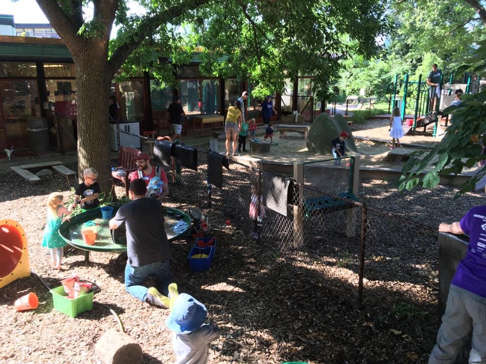 People and children playing in a shaded outdoor area