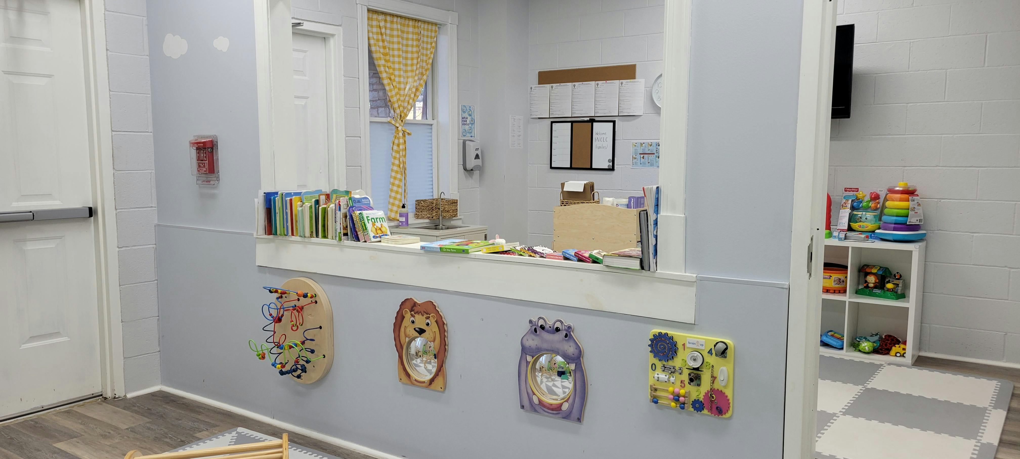 Playroom with a counter, books, toys, and interactive wall panels