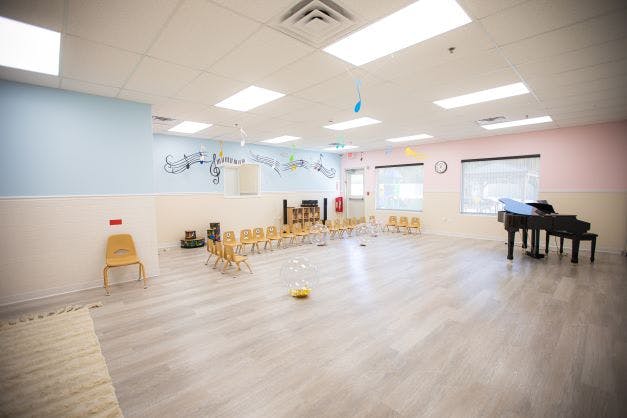 Empty classroom with small chairs arranged in a circle and a grand piano