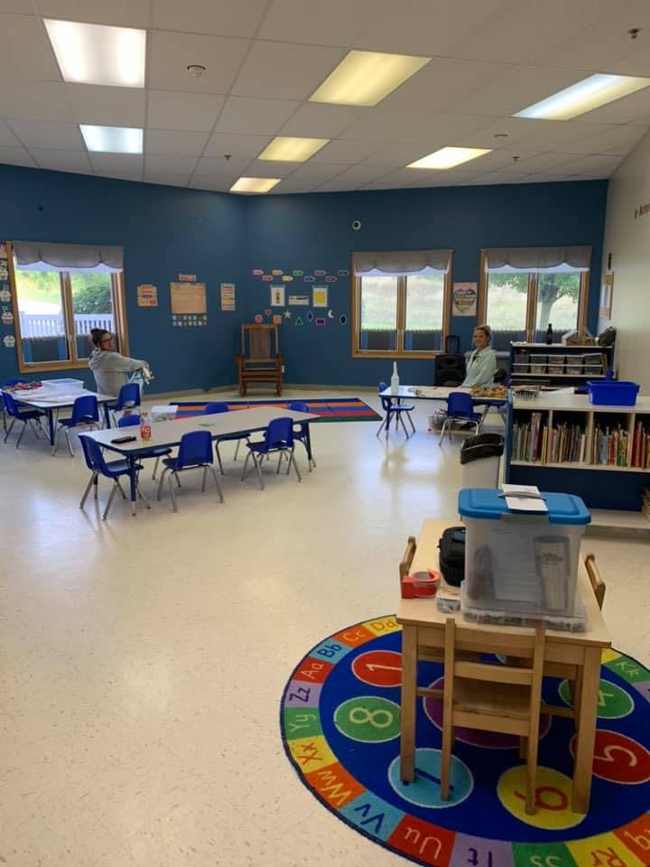 Classroom with tables, chairs, and two people