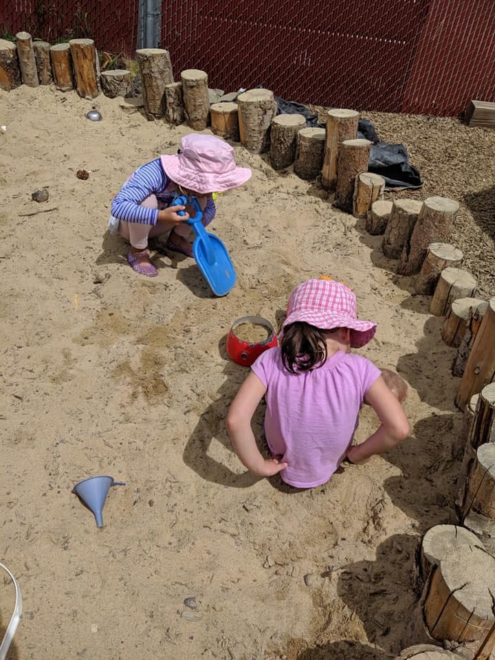 Two children playing in a sandbox