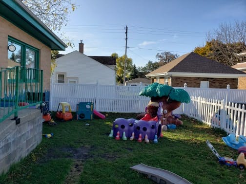 Backyard with a white picket fence and children's play equipment