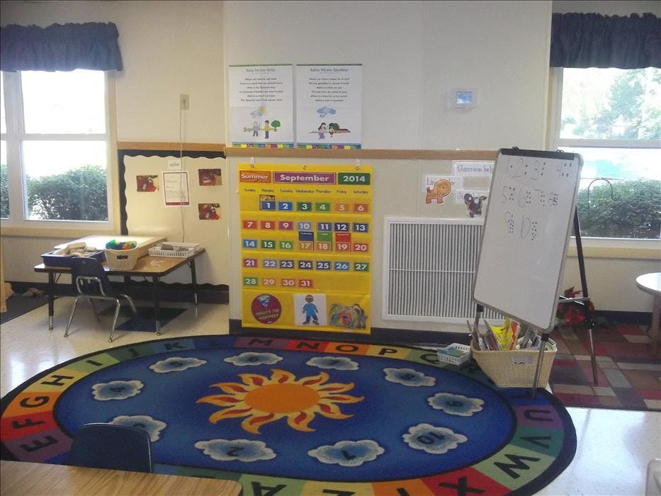 Classroom with a large circular rug, calendar, and whiteboard