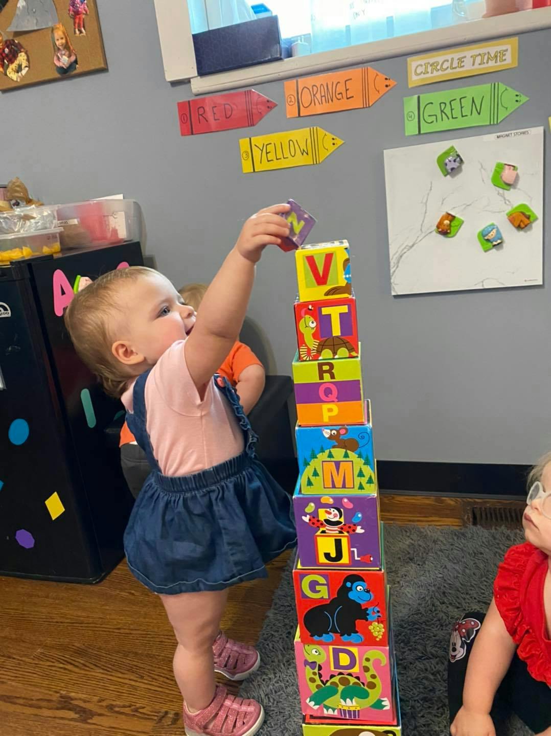Child stacking colorful alphabet blocks