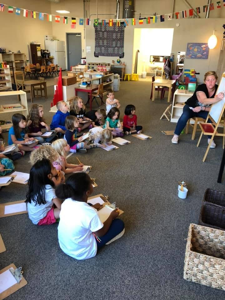Adult teaching a group of children in a classroom