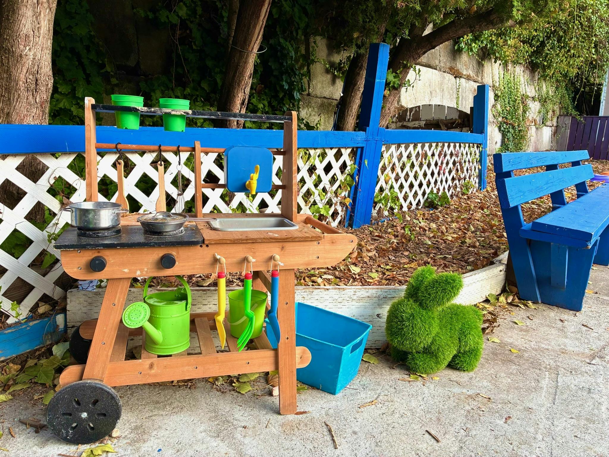 Wooden toy outdoor kitchen with plastic pots and tools