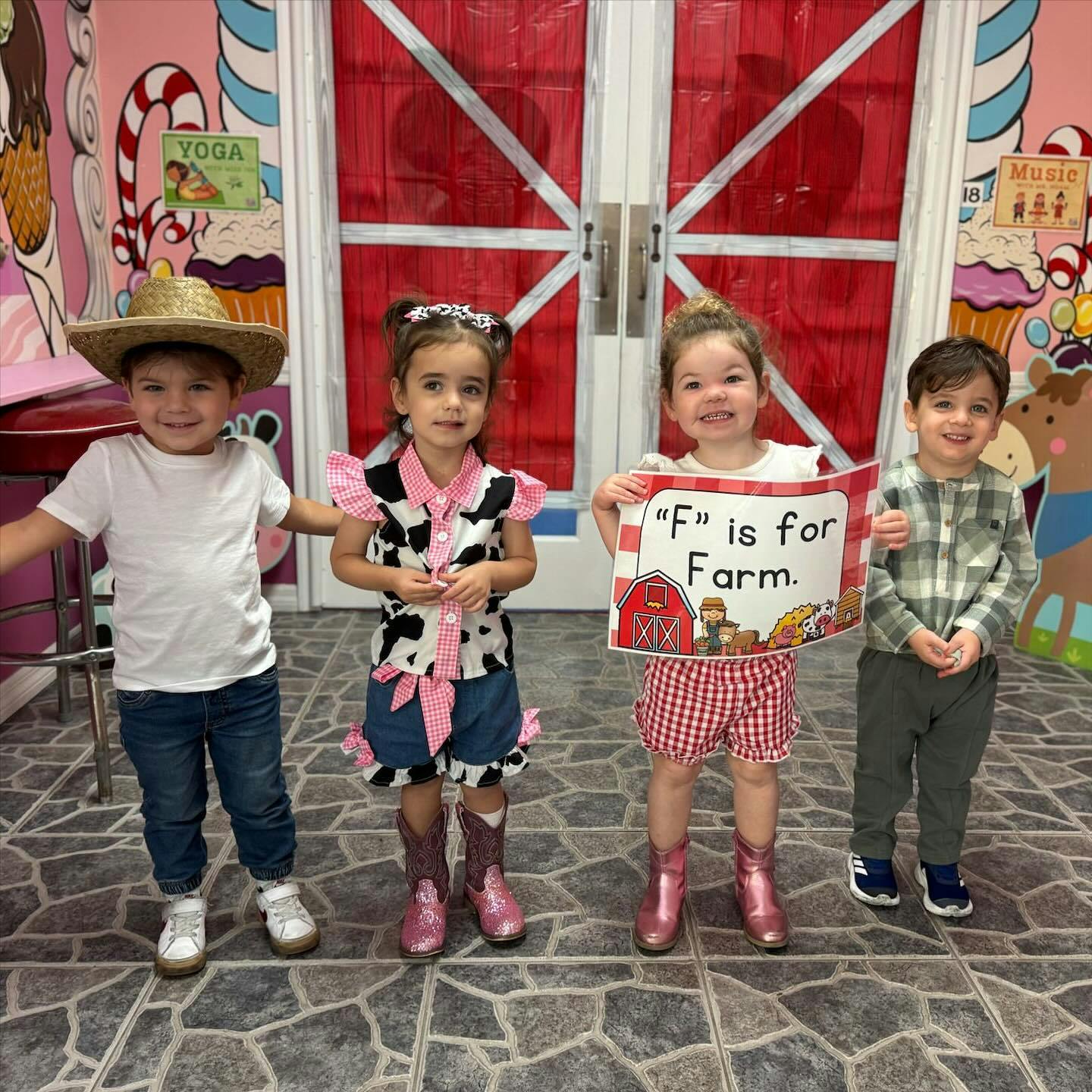 Four children in farm-themed costumes, one holding a sign that says "F" is for Farm