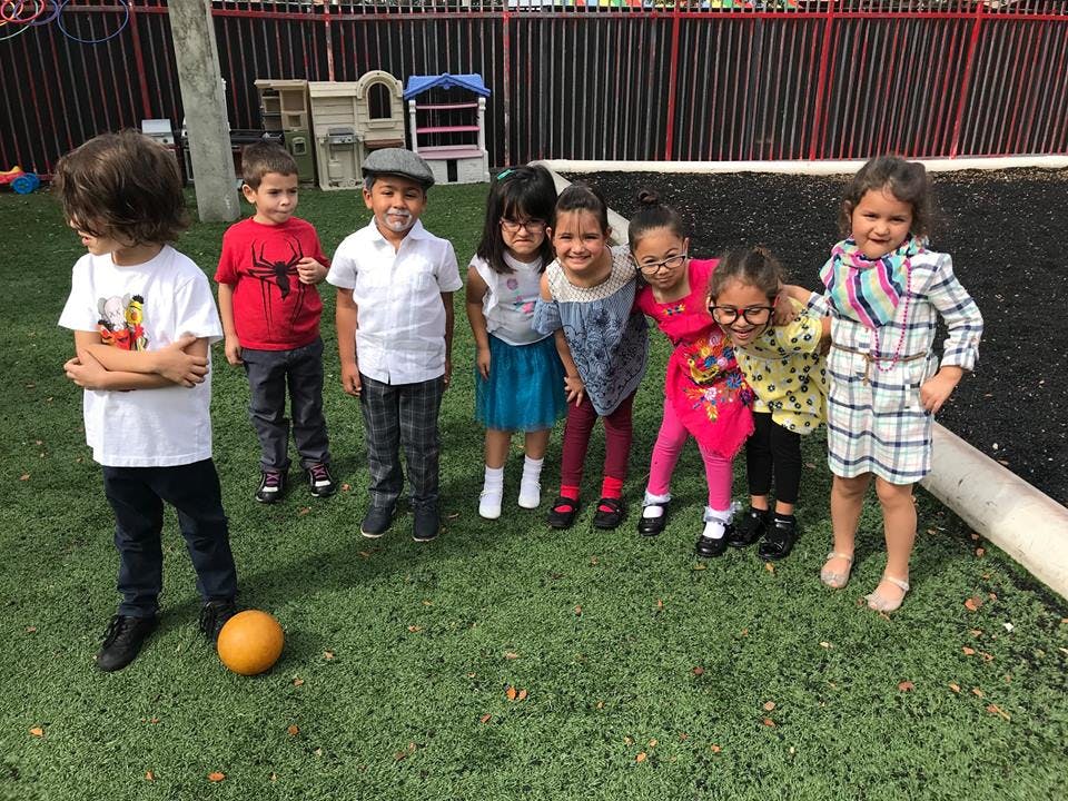 Group of children standing on grass with a ball