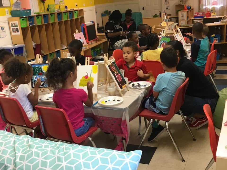Children painting at easels in a classroom