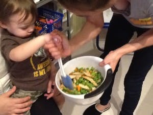 Adult and child mixing food in a bowl