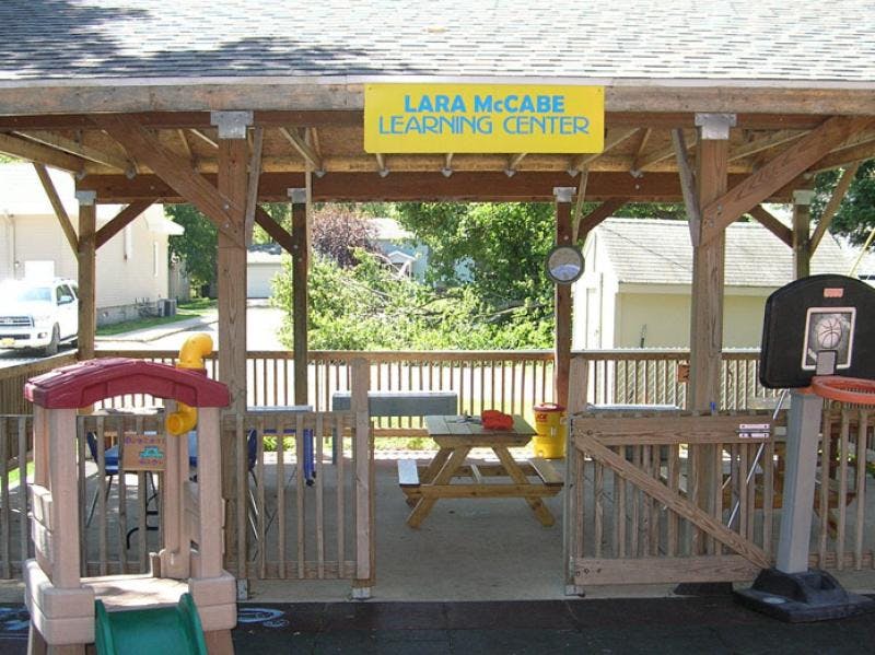 Outdoor play area with a slide, picnic table, and basketball hoop