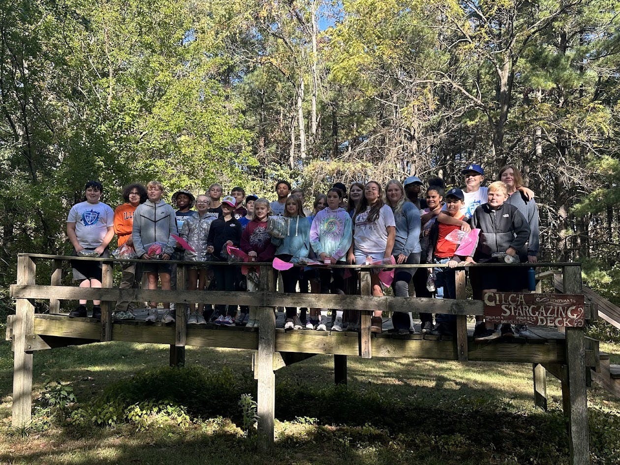 Group of teens standing on a wooden bridge outdoors