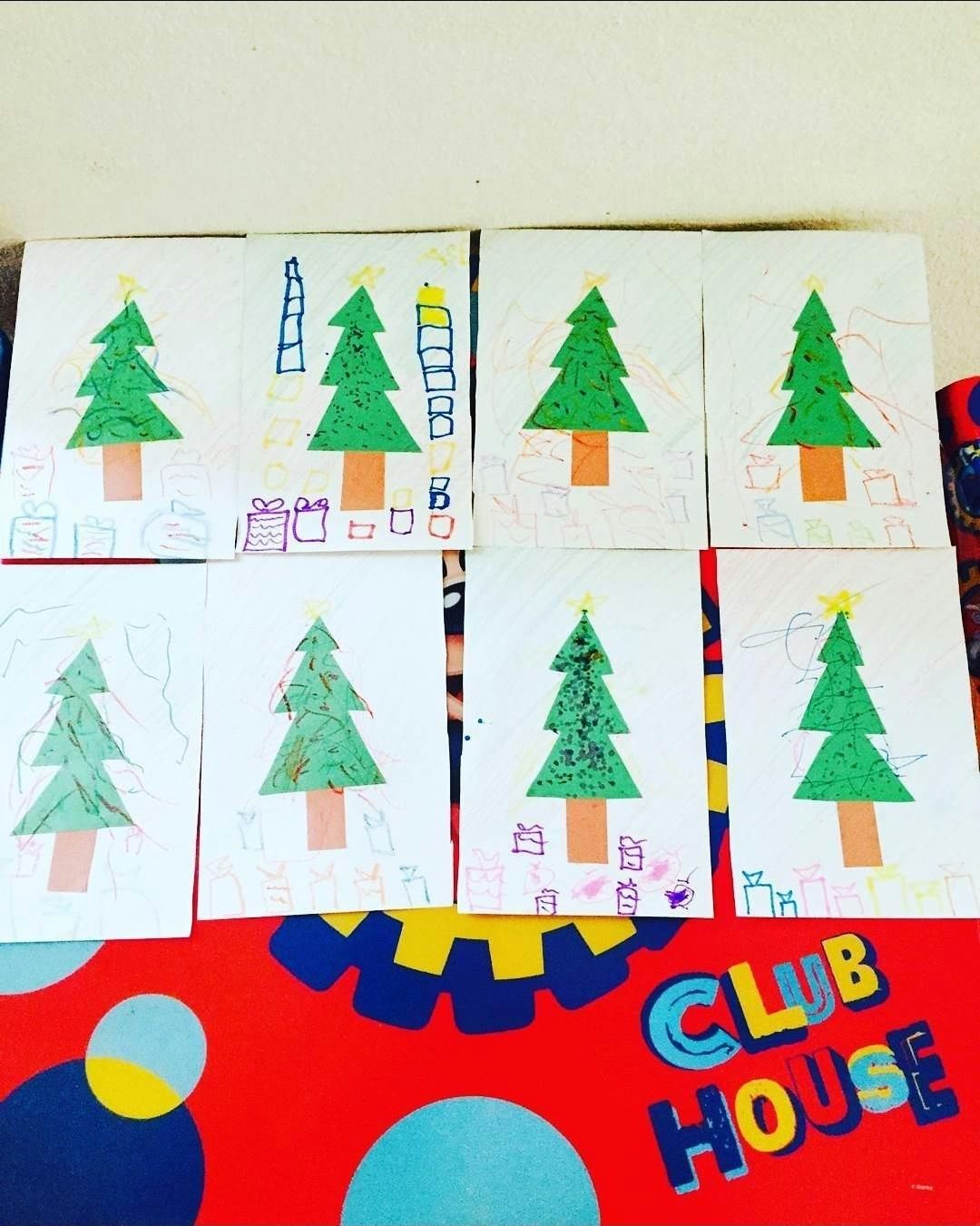 Drawings of Christmas trees displayed on a Clubhouse wall