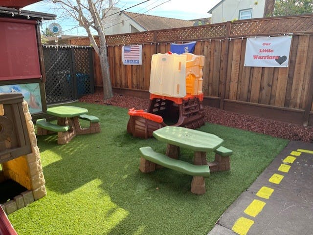 Playground with artificial turf, play structure, and picnic tables