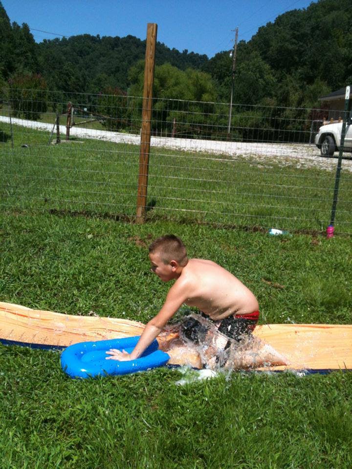 Child on a slip and slide with a blue inflatable