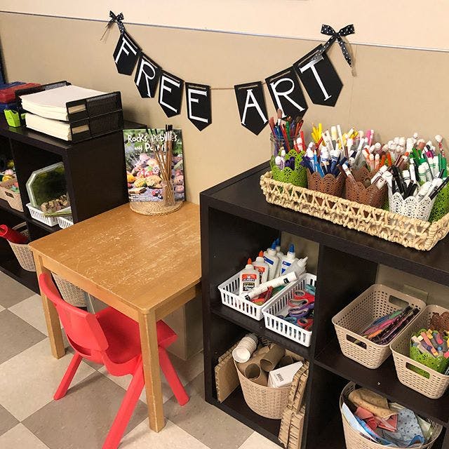 Classroom art station with a small table, chair, and shelves of supplies