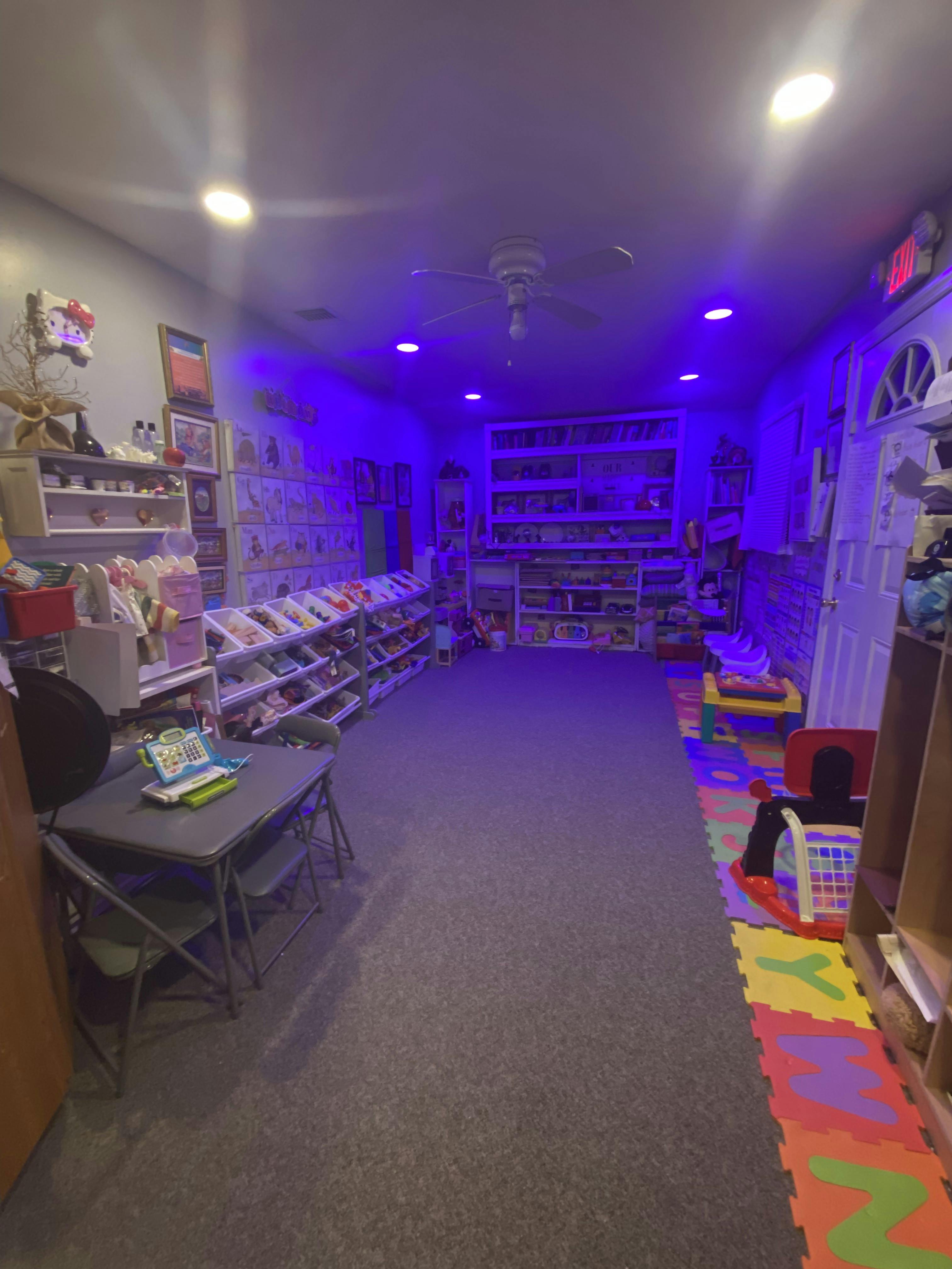 A playroom with storage for toys and colorful alphabet floor mats