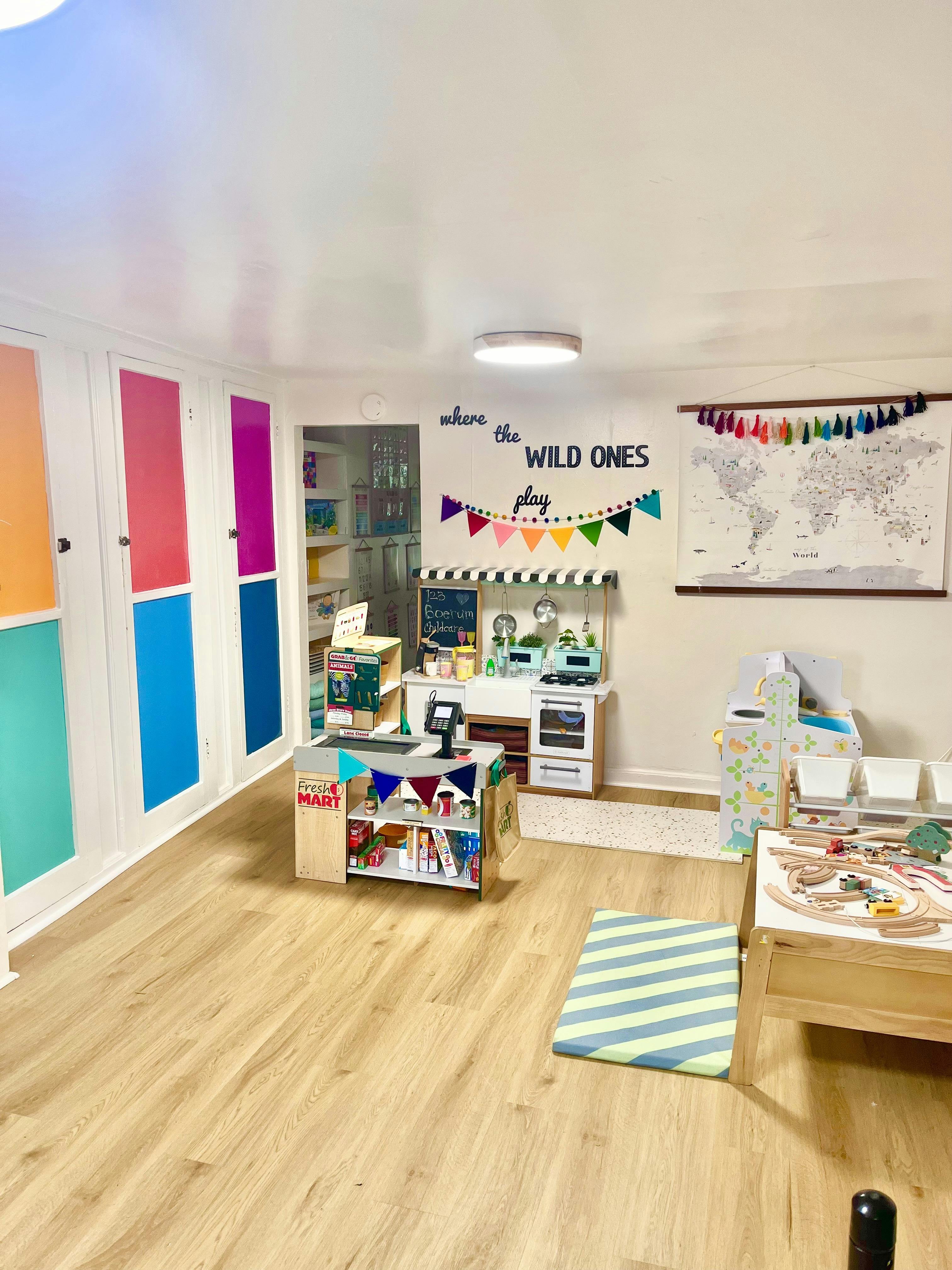 Playroom with toy kitchen, play market, and world map on the wall