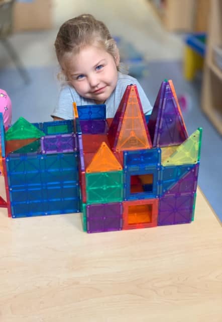 Child looking over a colorful magnetic block structure