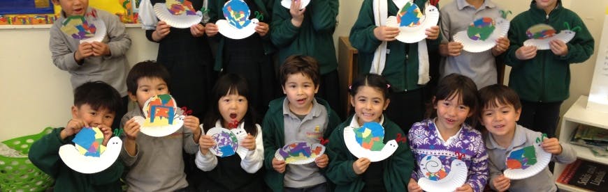 Group of children holding up paper plate crafts