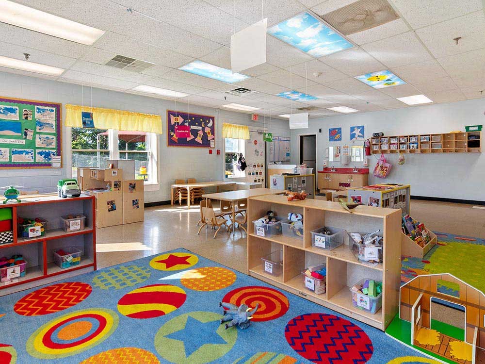 A colorful and bright empty classroom with play areas and small tables