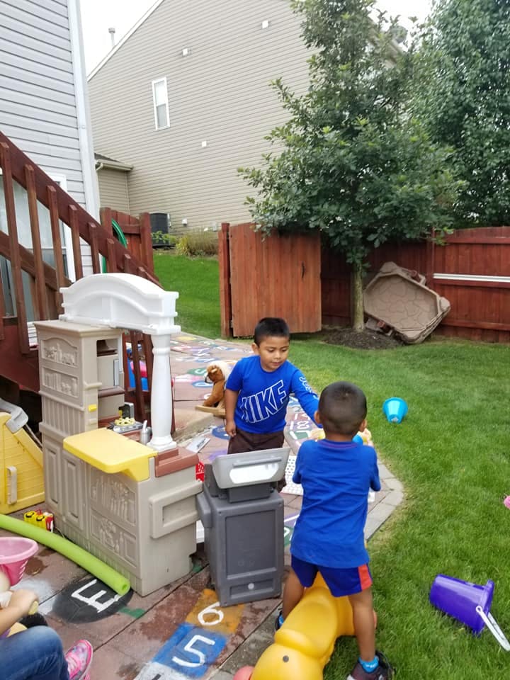 Two children playing outdoors with toys