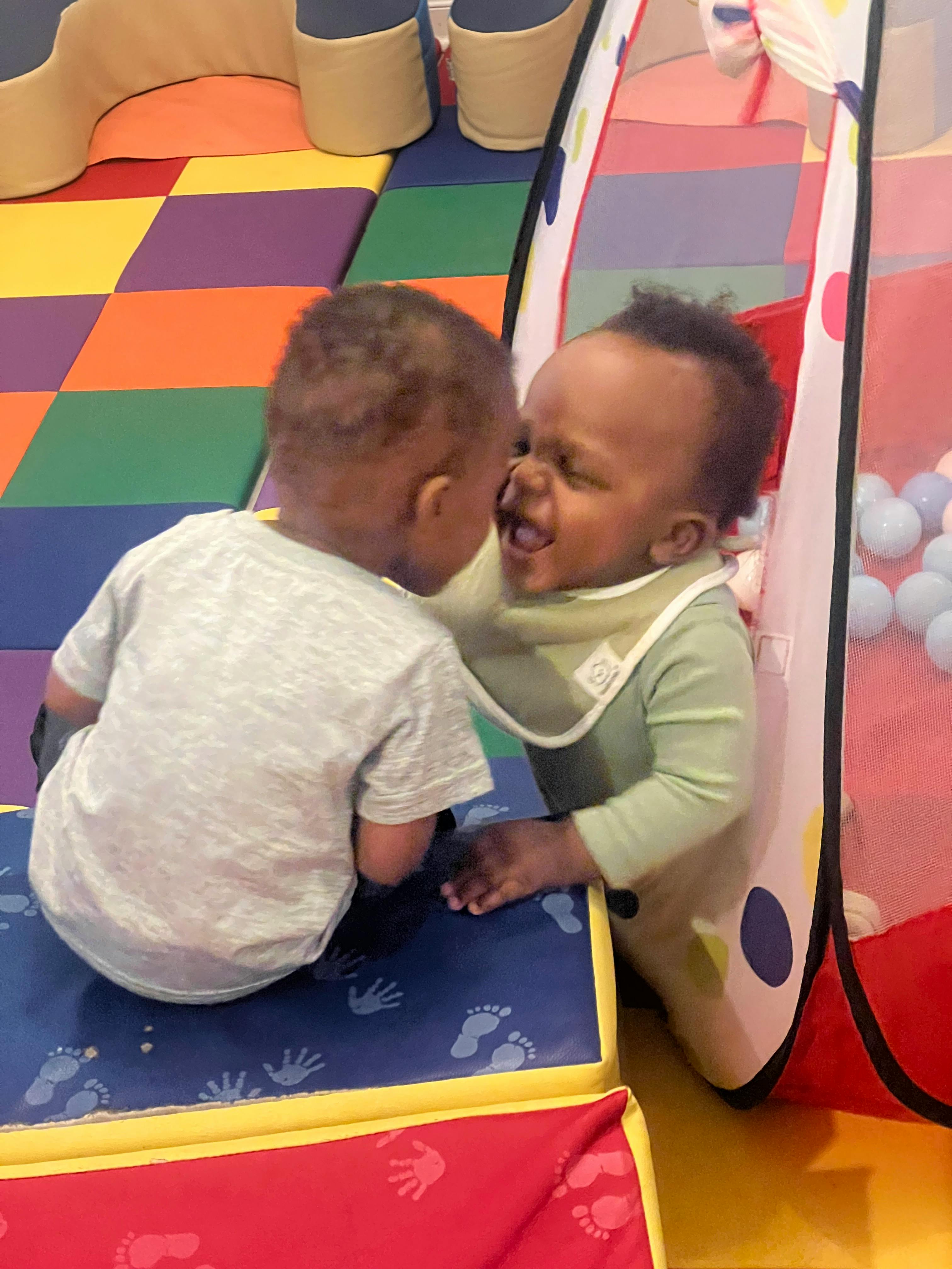 Two children playing together, one child with an open mouth