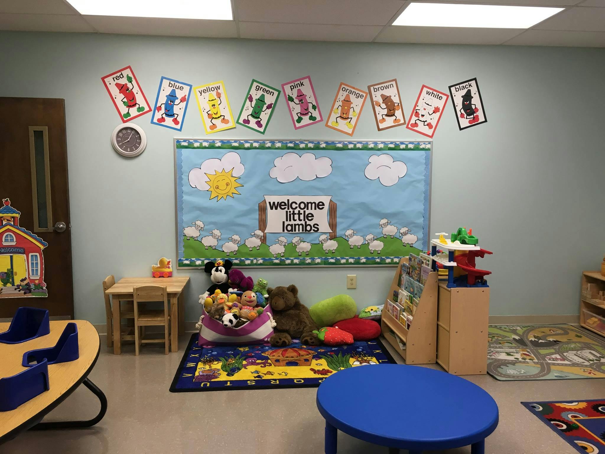 A classroom with a bulletin board that says "welcome little lambs"