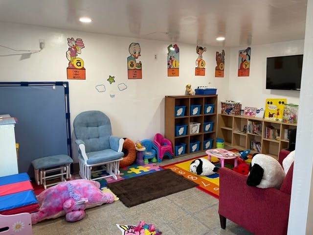 Playroom with a rocking chair, shelves, and colorful rugs