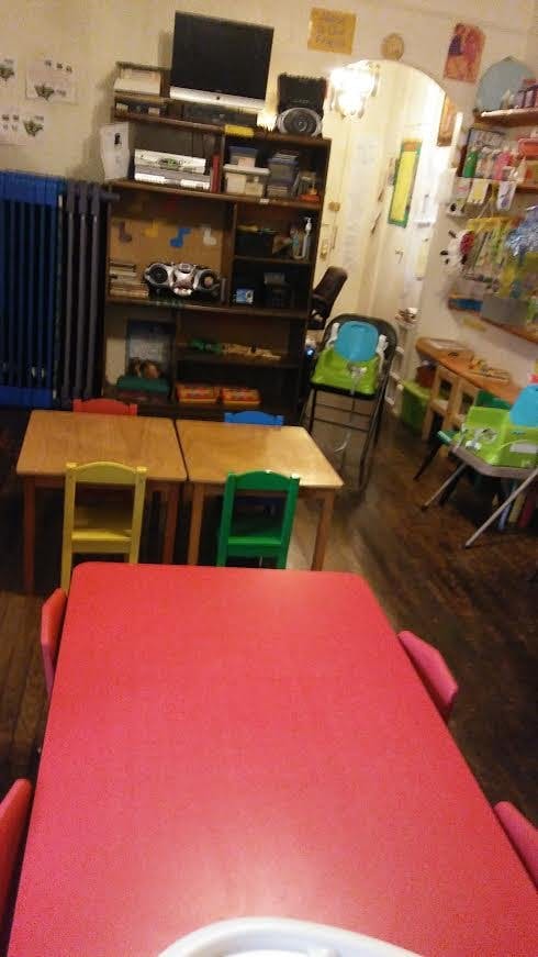 Classroom with small tables and chairs, shelves with electronics and electronics