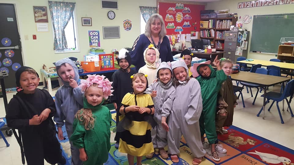 Adult and children in costumes in a classroom