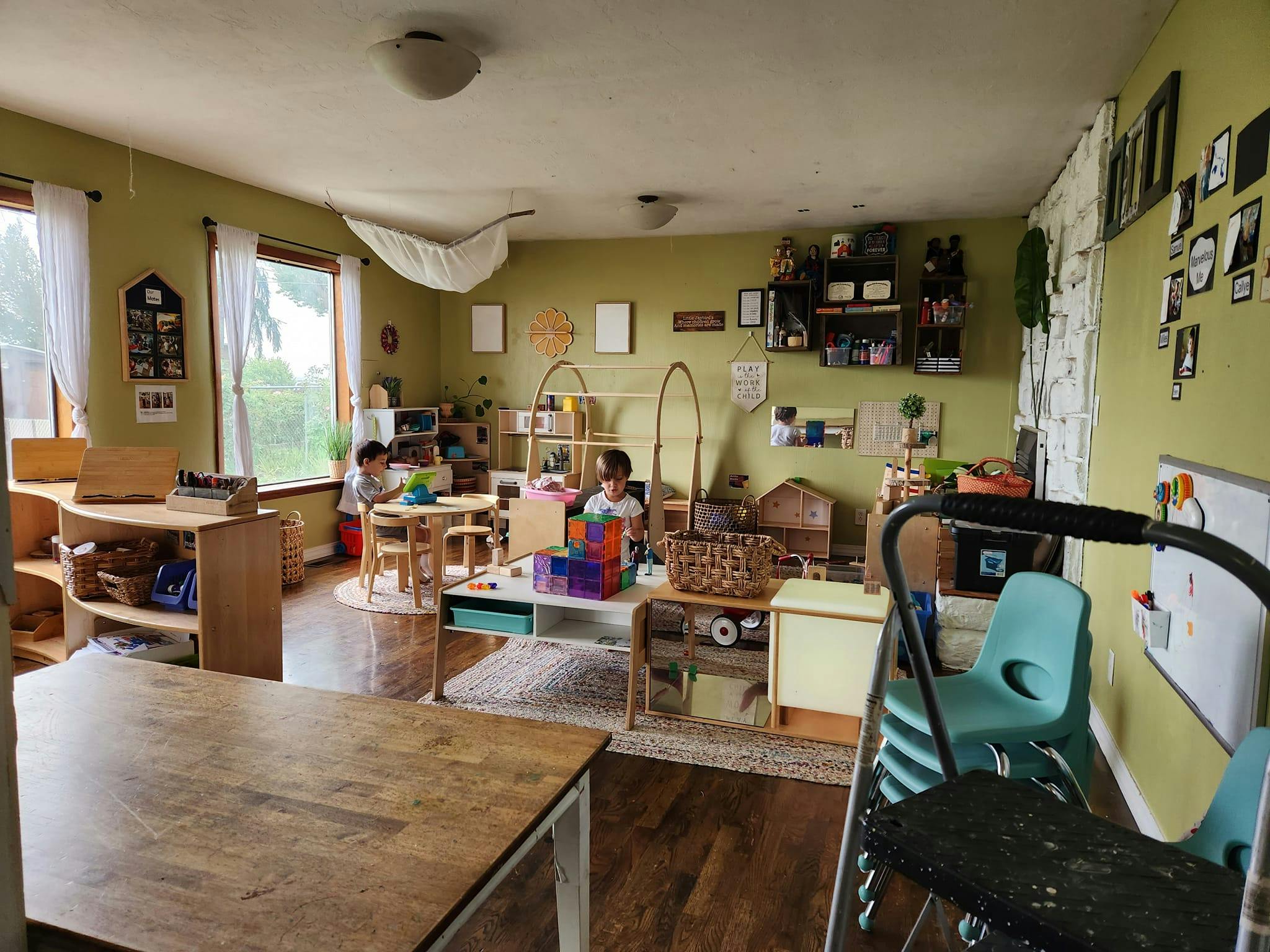 Two children playing in a classroom with tables and shelves