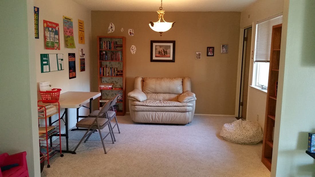 Living room with a sofa, table, chairs, and wall decorations