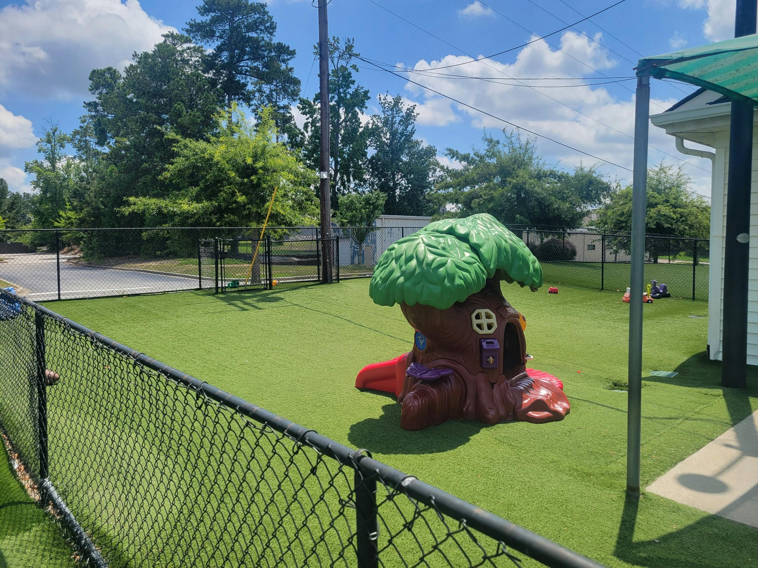 Playground with a tree-shaped play structure on artificial turf