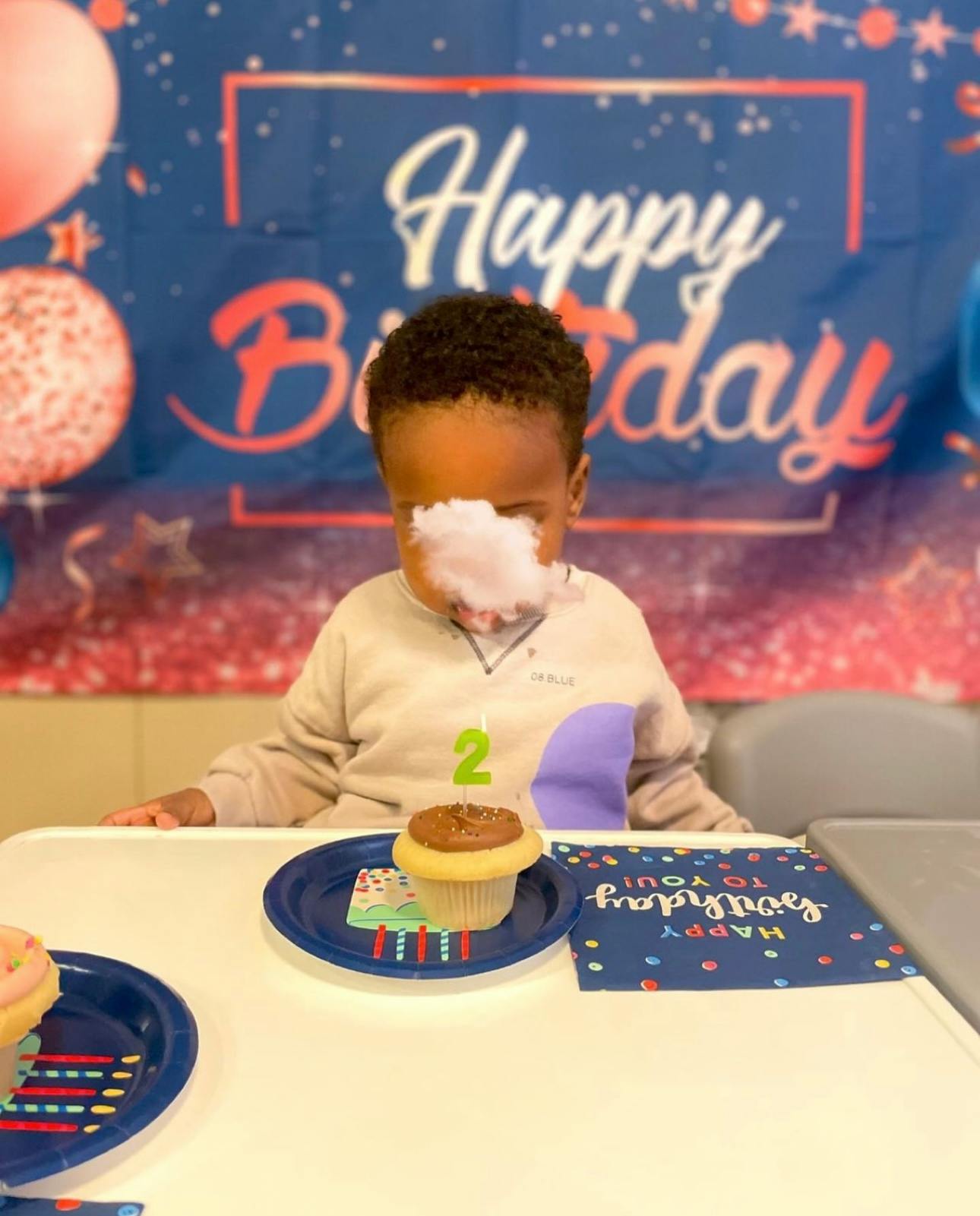 Child with cotton candy on face at a birthday celebration