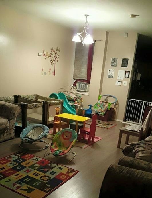 Living room with baby play items, including a rug, bouncers, and a small table