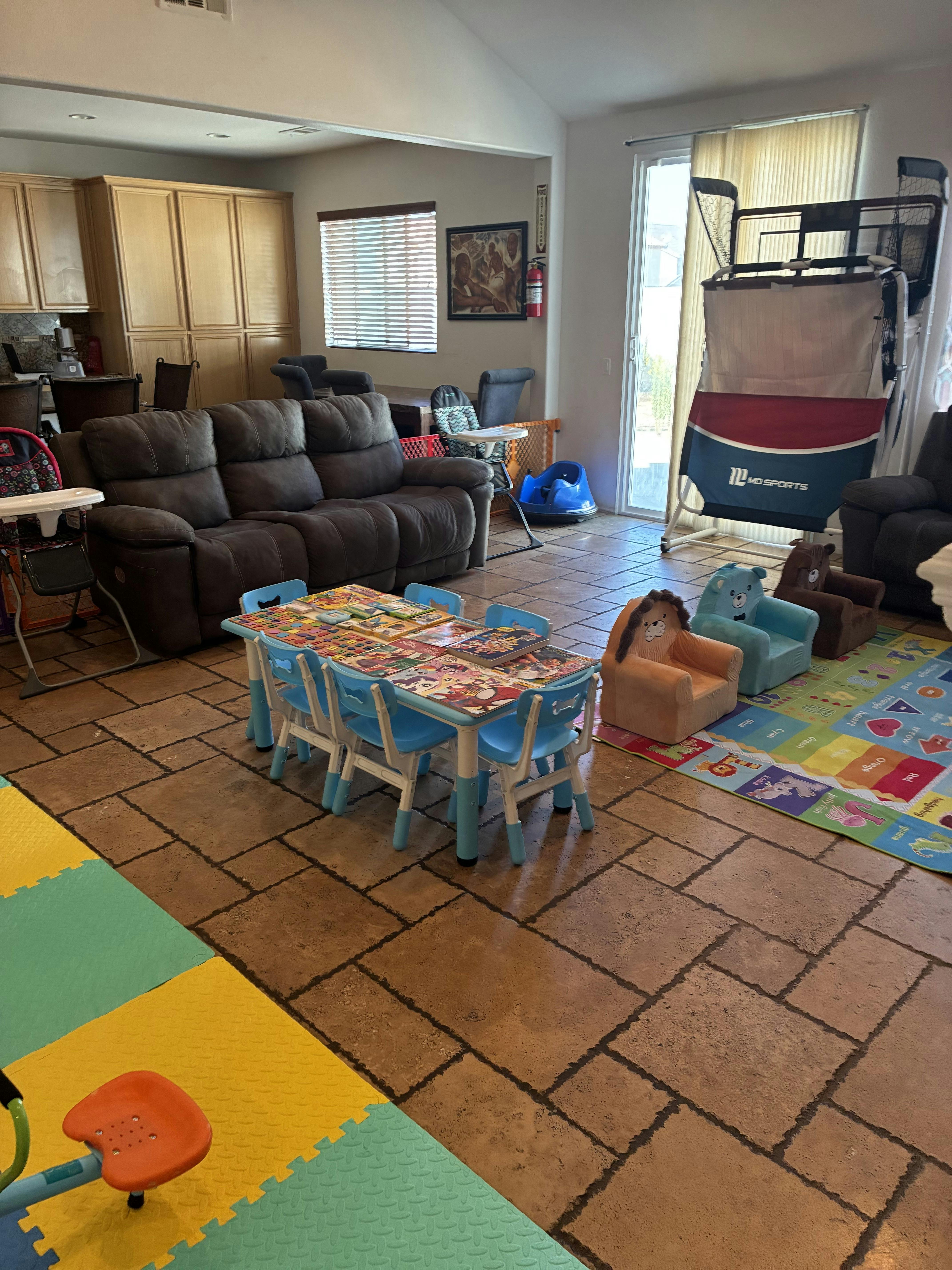 Living room with a sofa, child-sized table and chairs, and play area