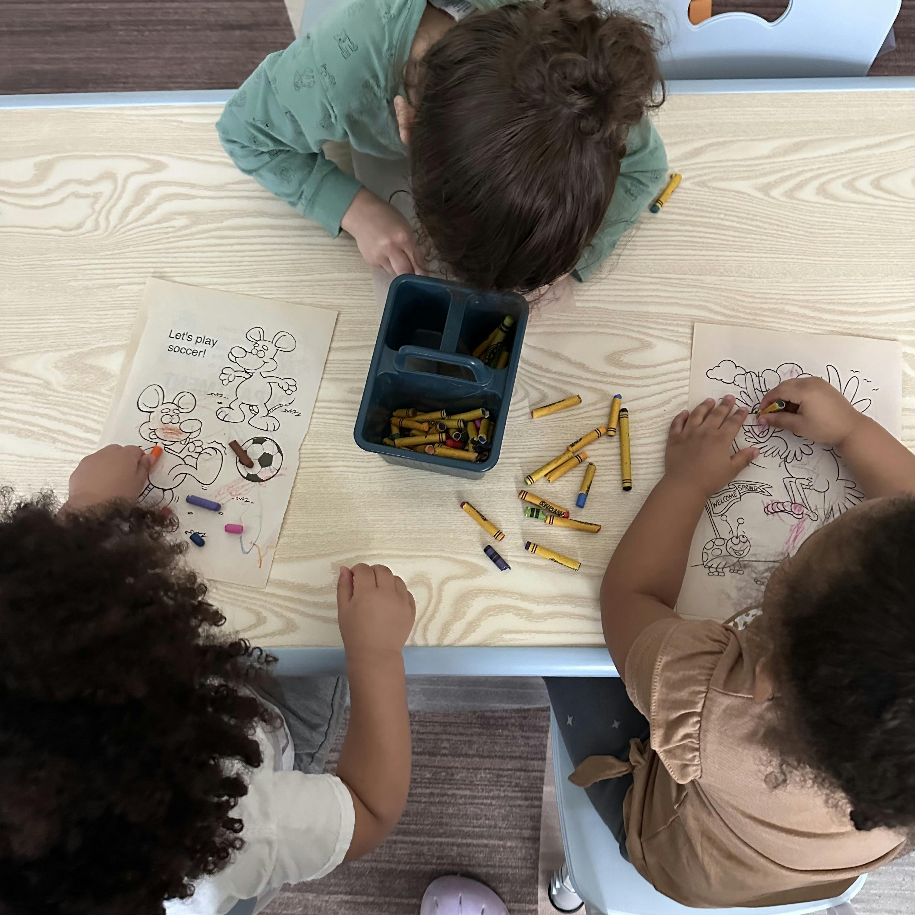 Three children coloring at a table