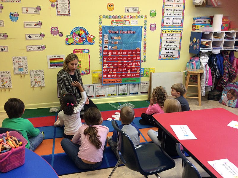 Adult teaching children in a classroom setting