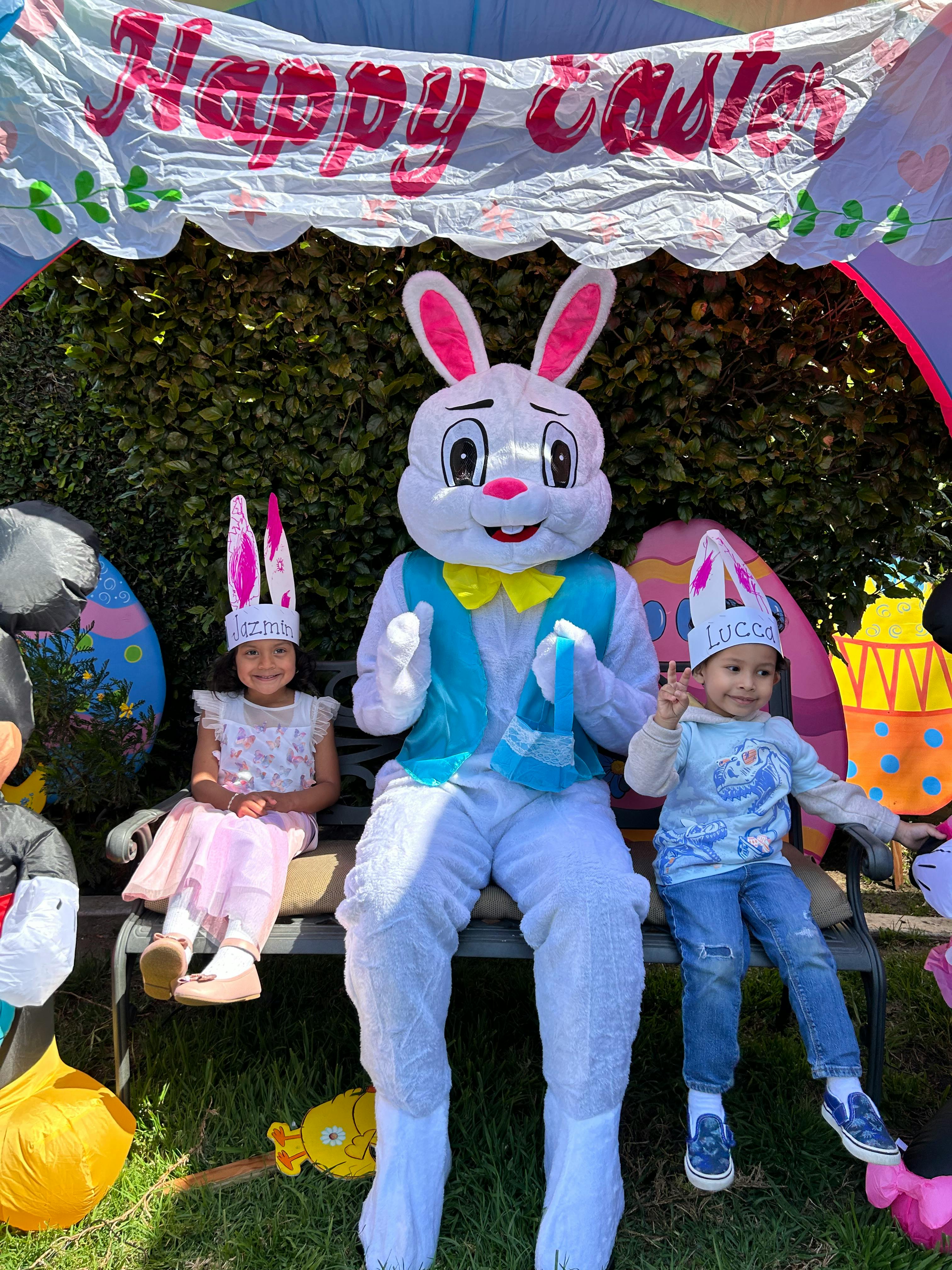 Easter bunny mascot sitting with two children wearing bunny ears