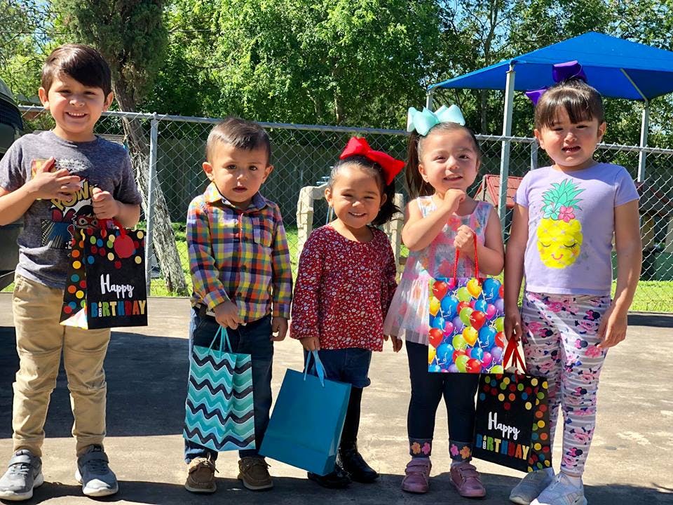 Five children holding gift bags, some with "Happy Birthday" text