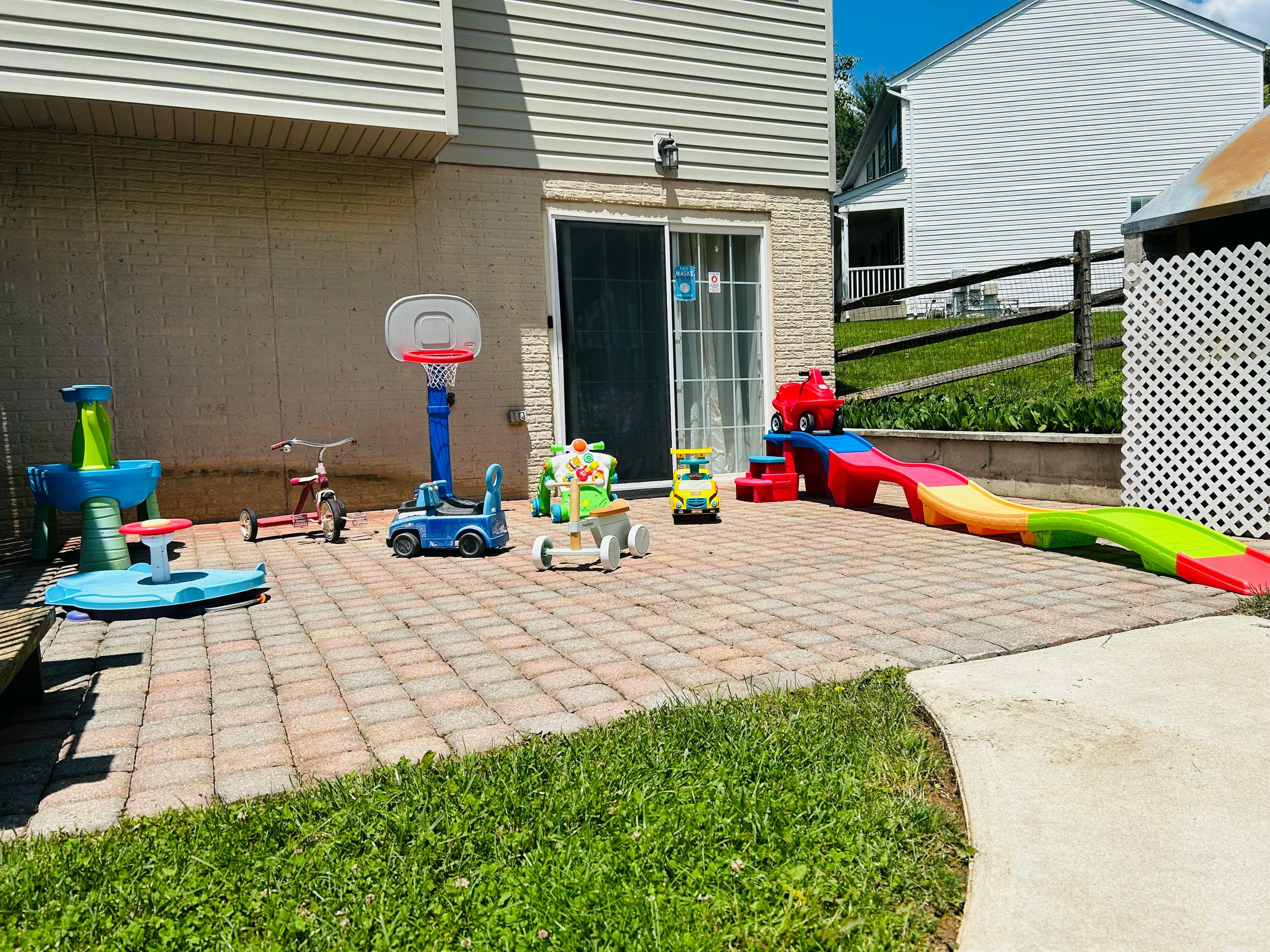 Patio with various children's toys including a basketball hoop and slide