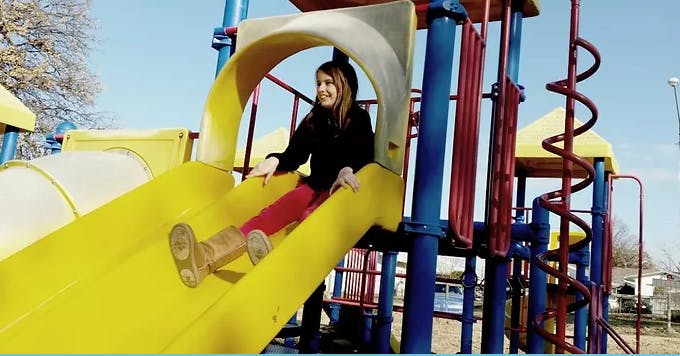 Person on a yellow playground slide