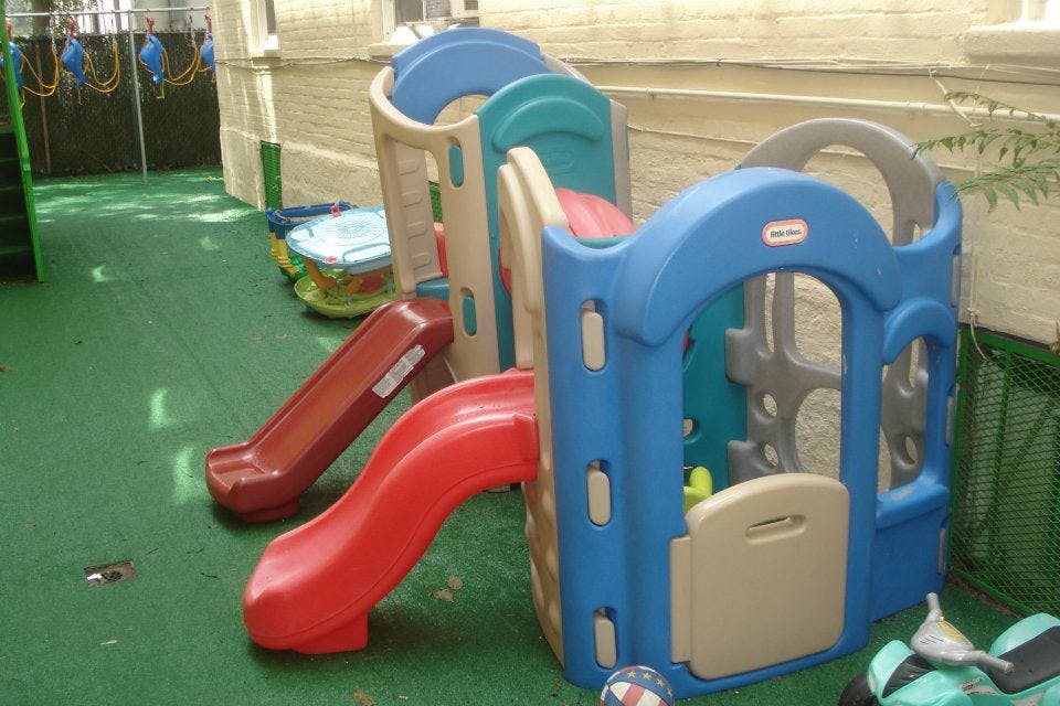 Plastic playground equipment with slides on green turf