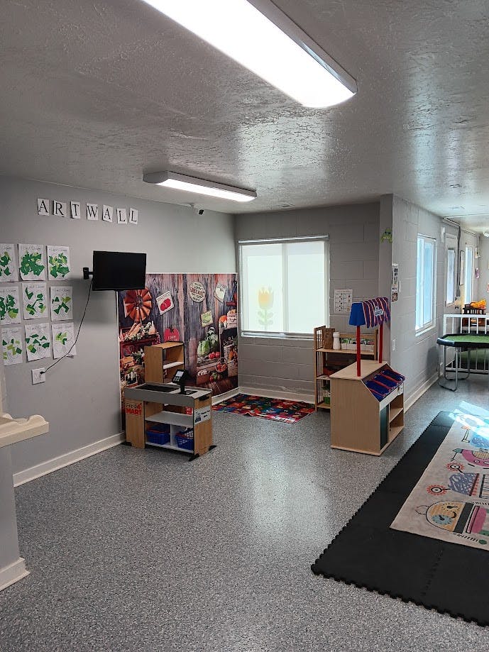 Classroom with play market, art wall, and windows