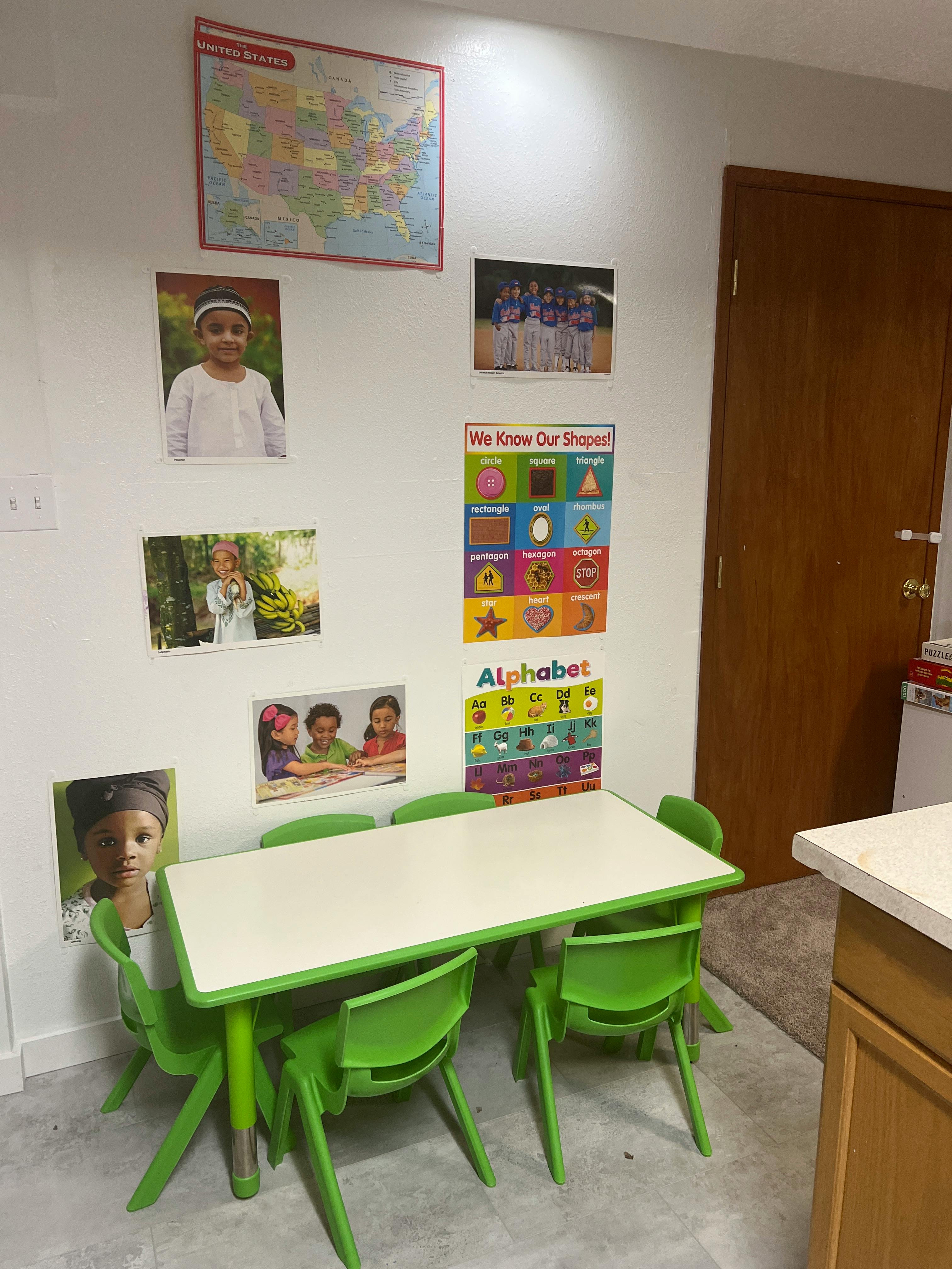 Classroom with small table and chairs, educational posters on the wall