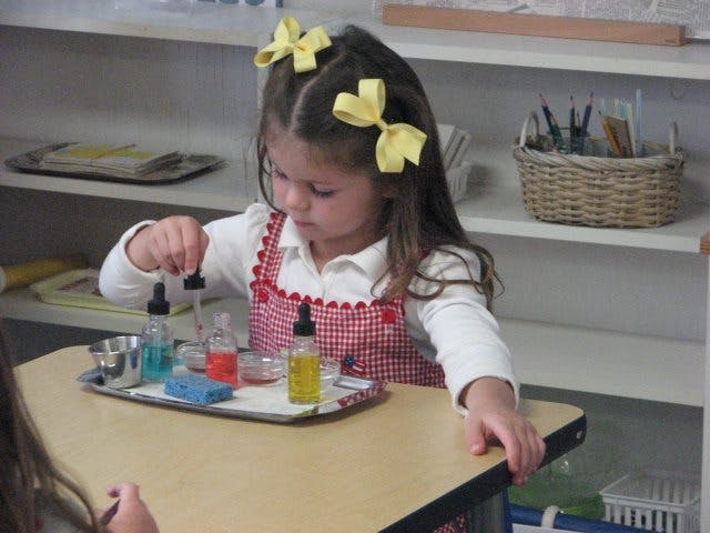 Child using droppers with liquids in a classroom