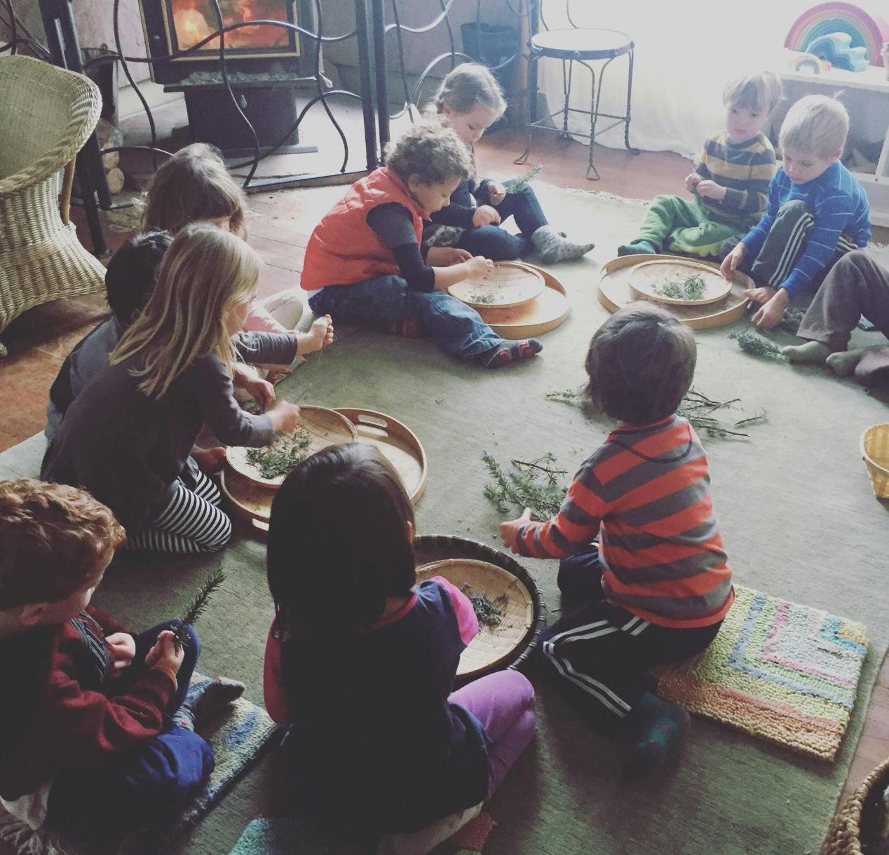 Children sitting on the floor playing with natural materials