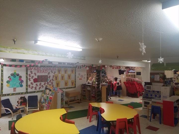 Classroom with yellow tables and chairs, decorated walls